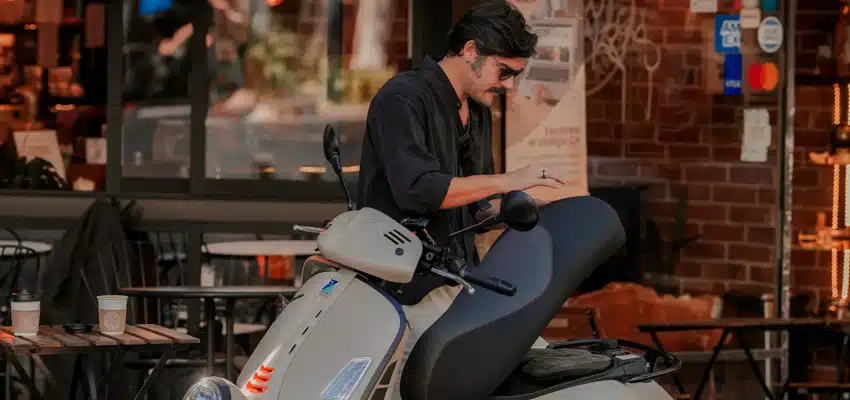 Hombre explorando su moto Vespa GTV 300 verificando especificaciones de Vespa Colombia