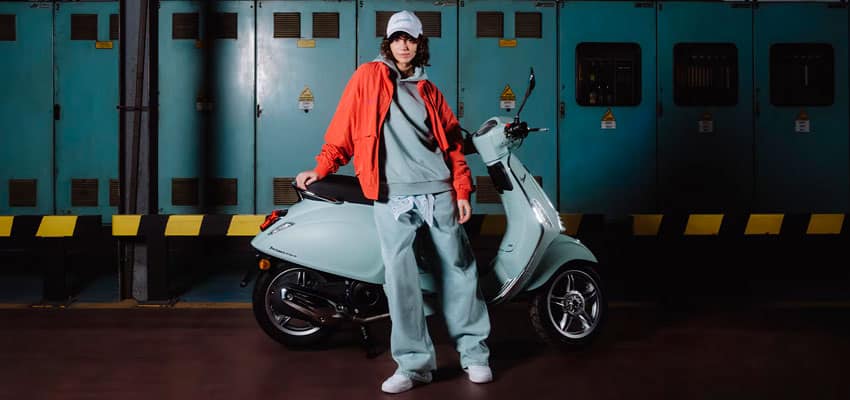 Mujer posando al lado de una de las mejores motos señoriteras automáticas en Colombia con Vespa Colombia